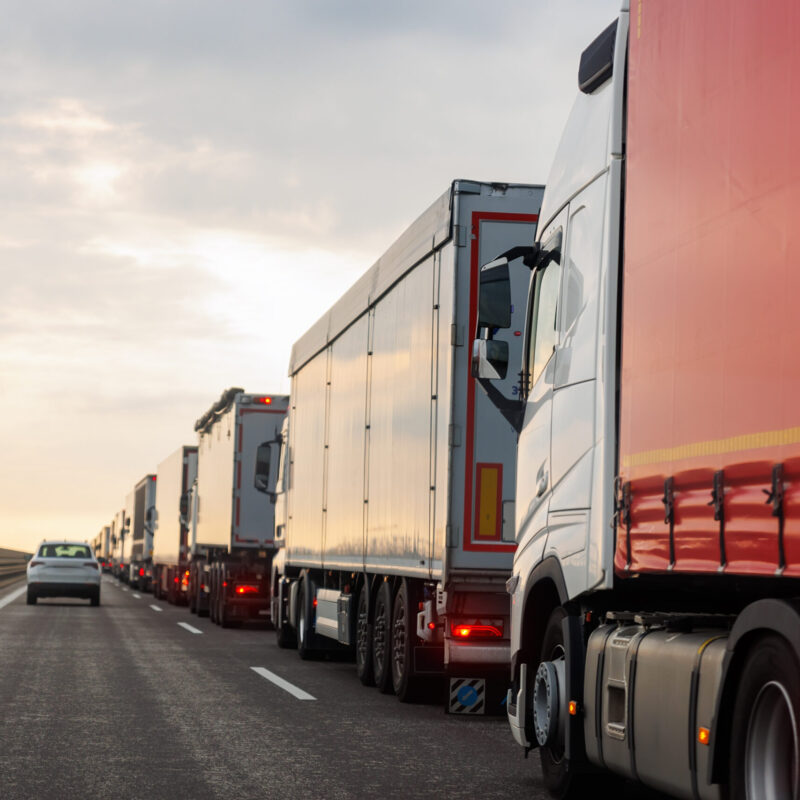 Queue of Trucks on Ukraine-Poland Border traffic jam at Sunset During Protest Roadblock. Business agricultural Logistics blockade action. Cargo lorry semi-trailers stuck.